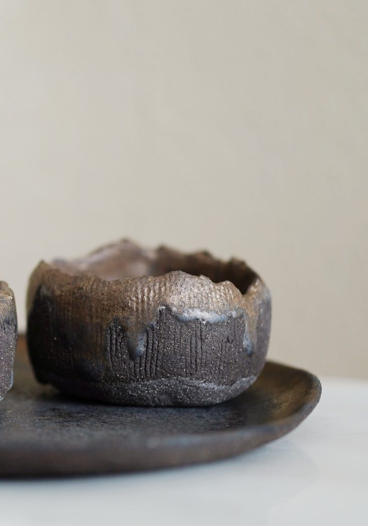 Große, dunkle Keramikvase aus Steinzeugkeramik auf einer Marmorplatte.