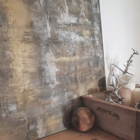 Abstraktes Kunstwerk in Naturtönen/ Erdtönen stehend auf einem Sideboard aus Holz.