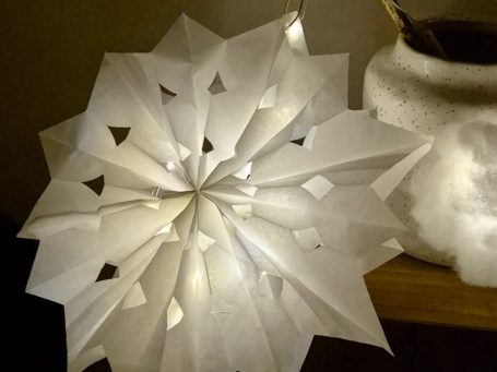 Eine weiße Sternlaterne aus Papier und mit Beleuchtung.