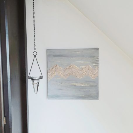 Abstrakte Wandkunst vor einer weißen Wand.