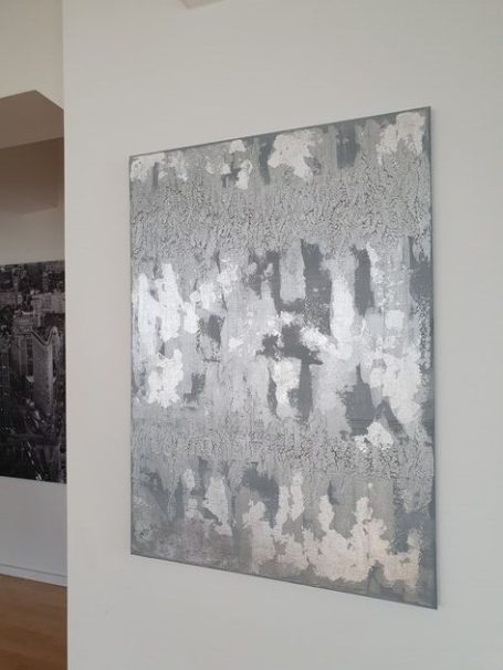 Abstraktes, silbernes Kunstwerk mit Texturen und Struktur auf hellem Hintergrund.